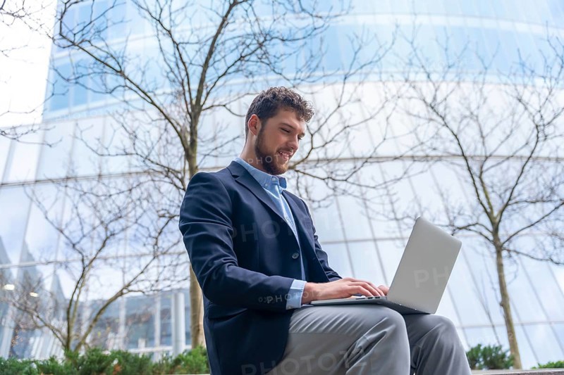 Young businessman or finance man looking at computer outside office