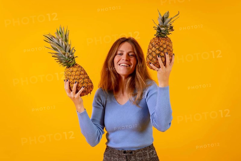 Vegetarian woman smiling with a cut pineapple