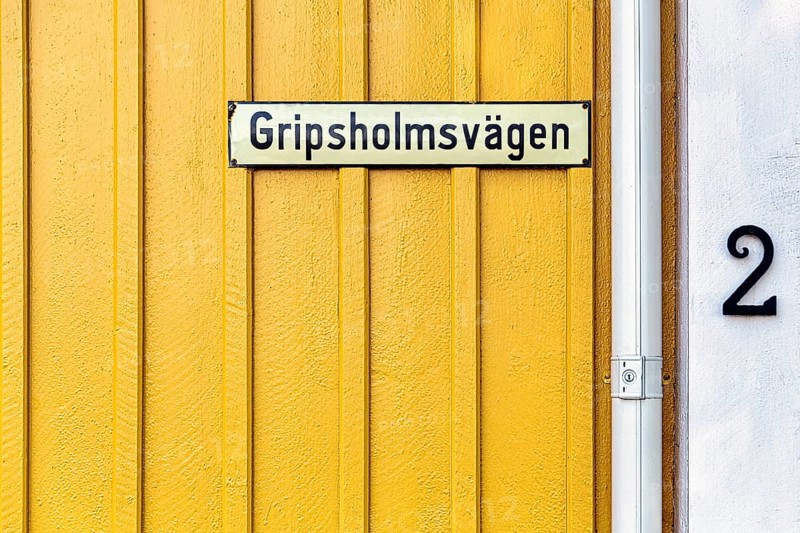 Street sign on a yellow painted wooden house