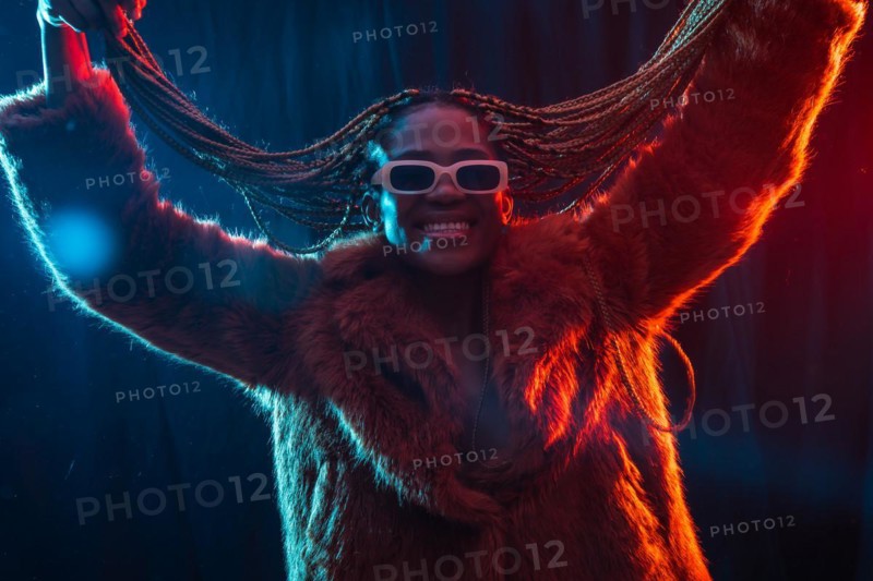 Black ethnic woman with braids with blue and red led lights