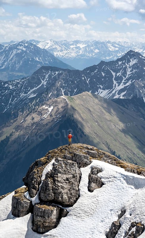 Hikers on the summit ridge of Thaneller in front of mountain landscape
