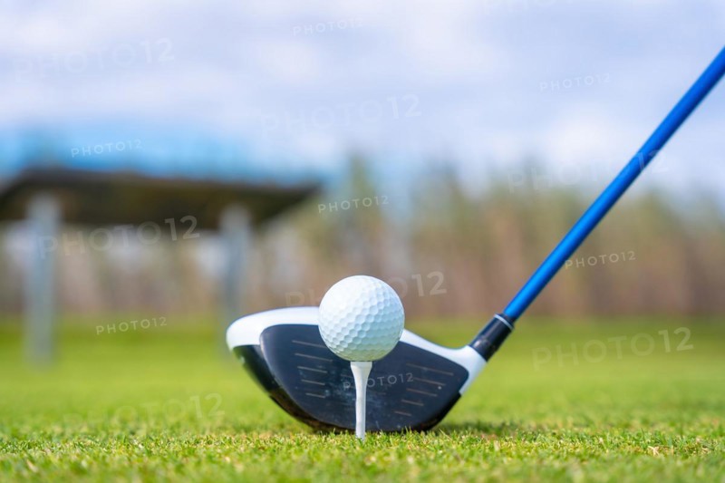 Man playing golf at golf club by a lake