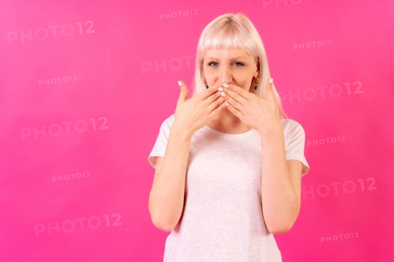 Blonde caucasian girl in studio on pink background