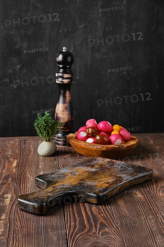 Rustic kitchen table with fresh vegetables and pepper mill blurred on background