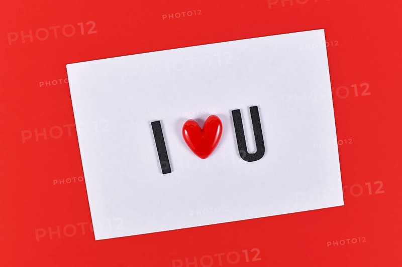 Valentine's day text 'I love you' spelled out with heart on white card on red background