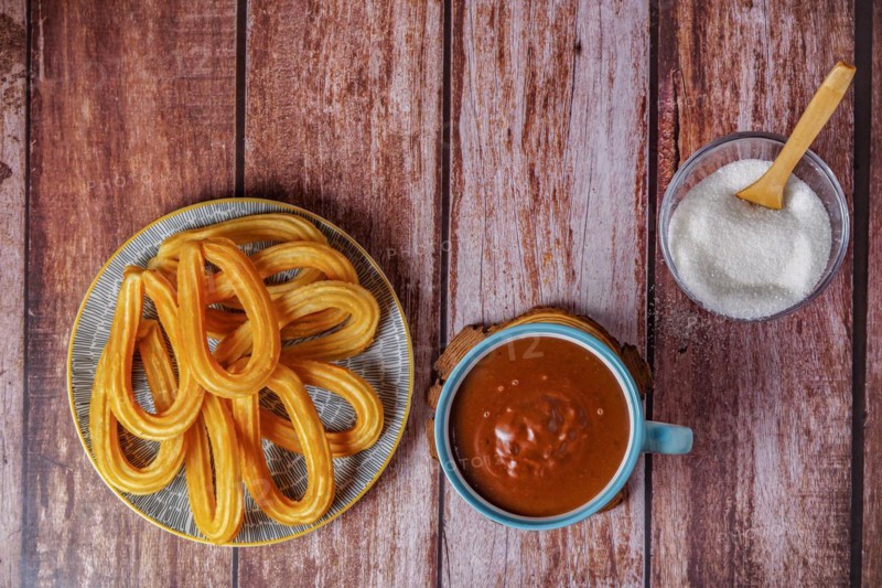 Hot chocolate with churros in a white and blue cup