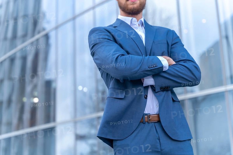 Unrecognizable person corporate businessman outside the office in a glass building