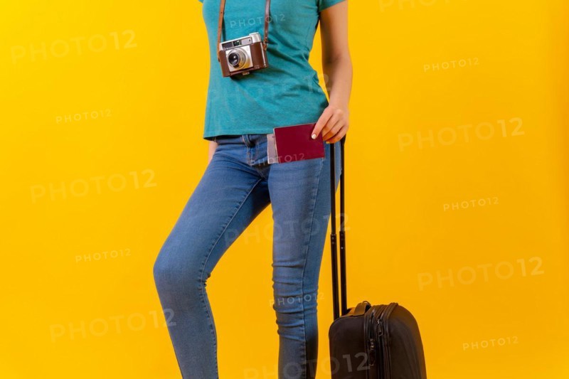 Unrecognizable person tourist with suitcase and passport