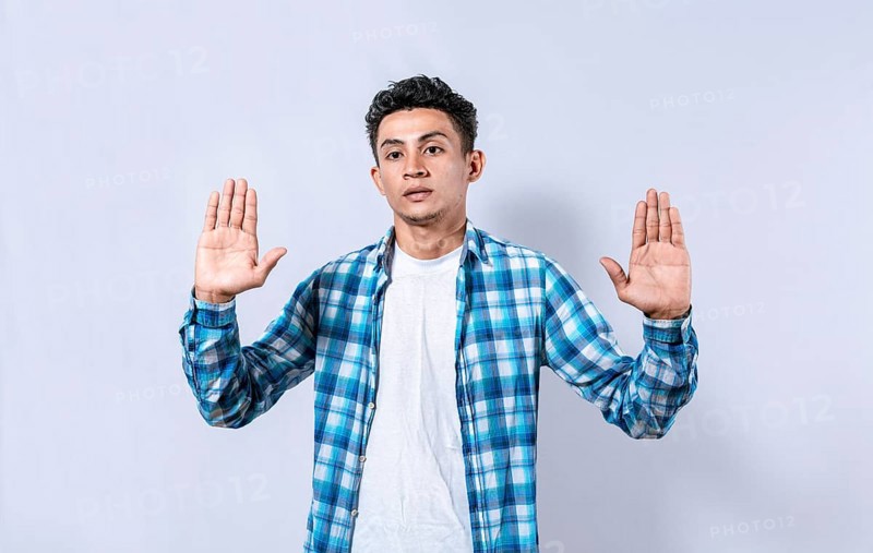 Scared and horrified man with raised palms