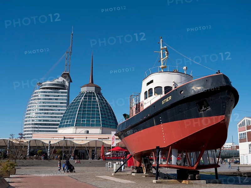 Tugboat Stier in the German Maritime Museum and in the background the glass dome of the restaurant and modern futuristic skyscrapers ATLANTIC Hotels SAIL City