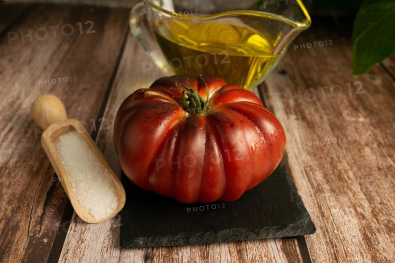 Moorish tomatoes with jar of olive oil and wooden spoon with salt