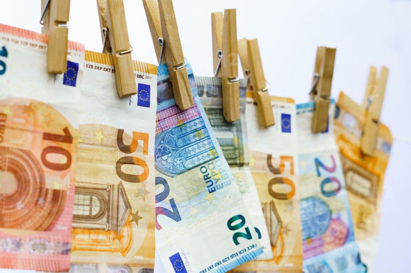 Euro banknotes hung on a clothesline with clothespins white background for copy space