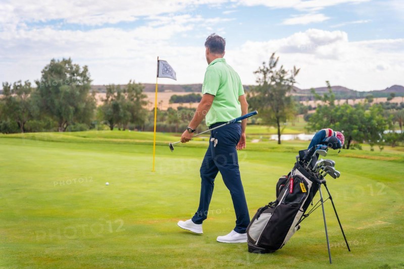 Caucasian professional golf player on the green preparing for the shot