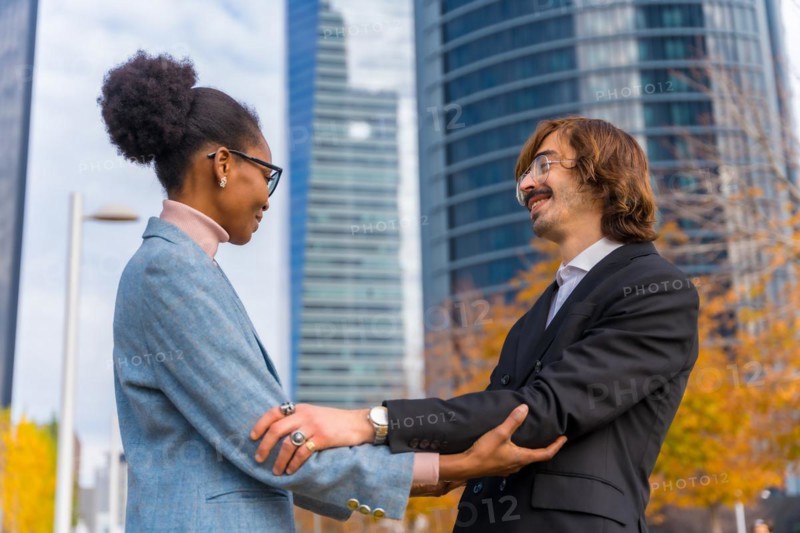 Multiethnic businessmen and businesswomen greeting each other