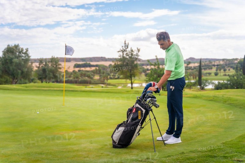 Caucasian professional golf player on a golf course on the green preparing for the shot