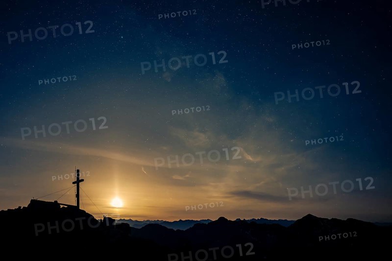 Summit cross of the Namloser Wetterspitze at full moon and Lechtaler Alps