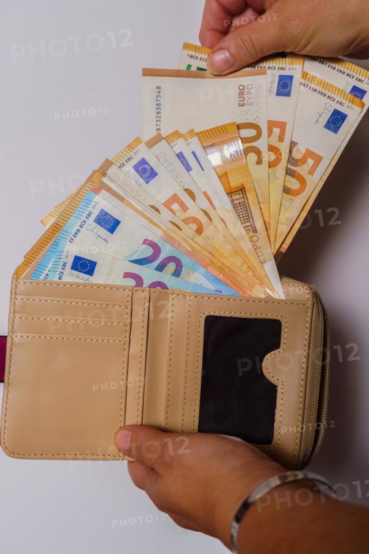 Woman's hands taking euro banknotes out of her wallet with white background and copy space