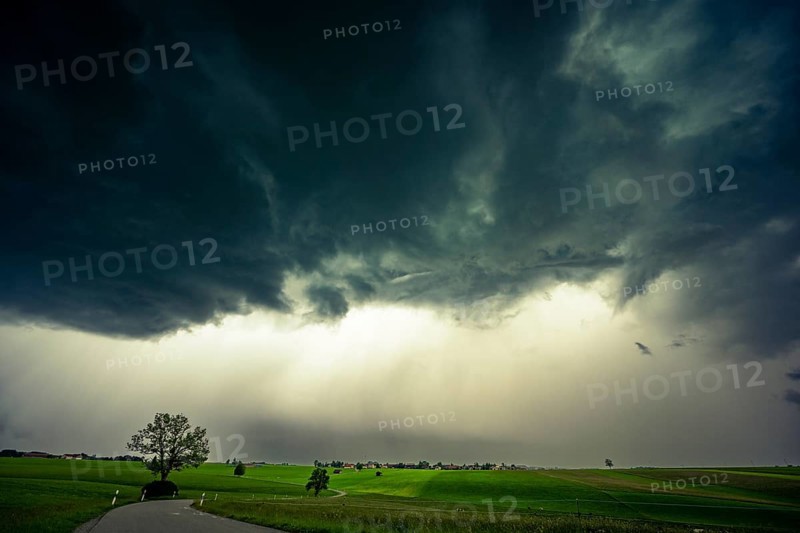 Road and meadows with thunderstorm sky in the background