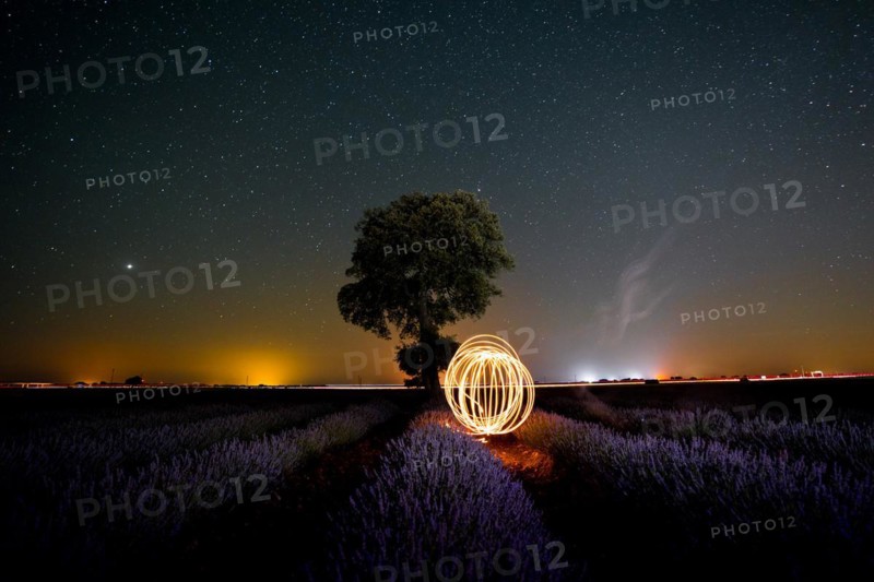 Rings of light in the milky way in a summer lavender field with a starry sky