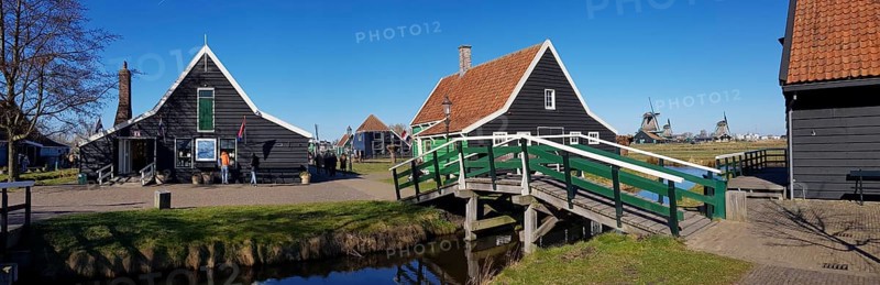Panoramic photo of Traditional old farmhouse and bridge over a canal in the museum village of Zaanse Schans