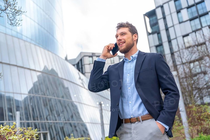 Male businessman or entrepreneur talking on the phone outside the office