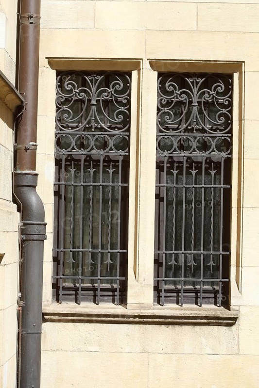 Window with ornate window grille on a house wall