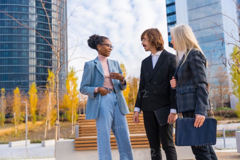 Multi ethnic business colleagues or executives talking to each other in a business park