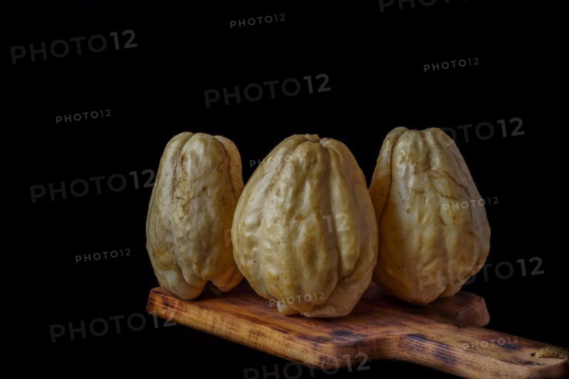 Chayotes isolated on a black background on a wooden board