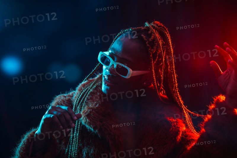 Black ethnic woman with braids with blue and red led lights