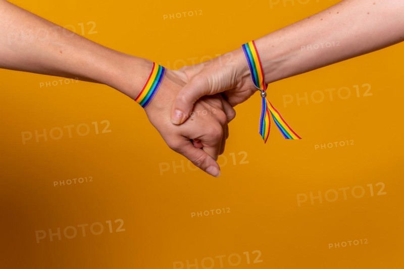 Detail of two hands of two women shaking hands with a bracelet