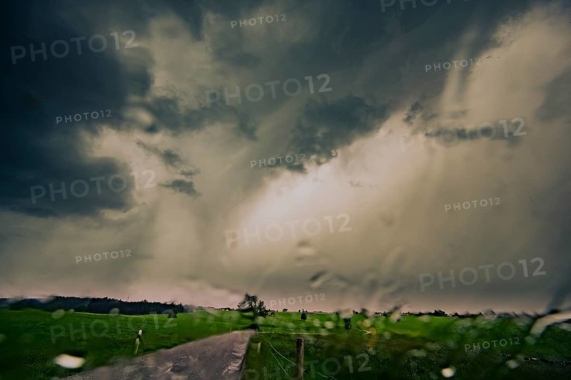 Road and meadows with thunderstorm sky in the background