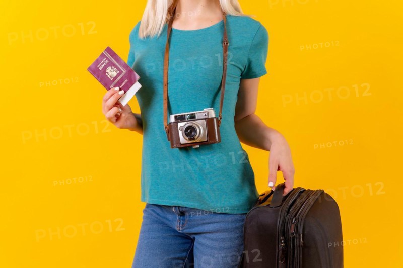 Unrecognizable person tourist with suitcase and passport