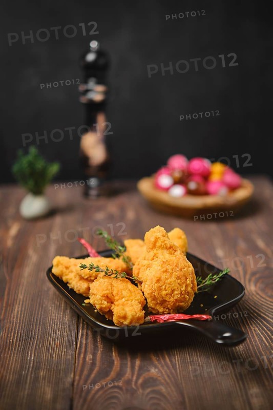 Selective focus photo of deep fried breaded chicken wings on shabby serving board