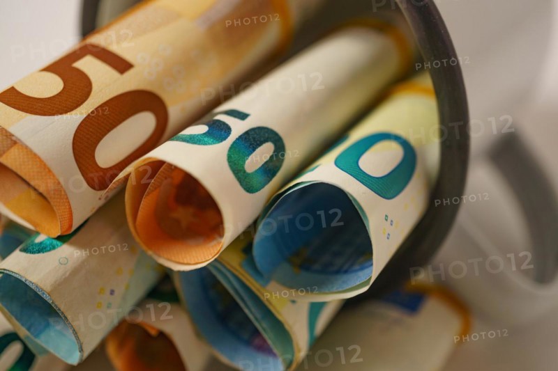 Rolled euro banknotes in a white cup with white background and copy space