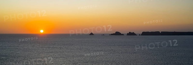 Sea cliffs at the Pointe de Pen-Hir and Les Tas de Pois sea stacks silhouetted against sunset on the Crozon Peninsula