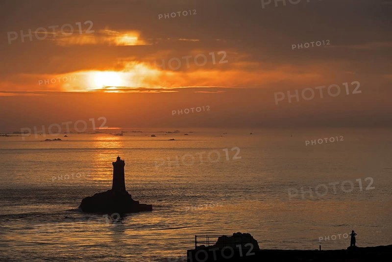 The lighthouse La Vieille in the strait Raz de Sein silhouetted against sunset at the Pointe du Raz