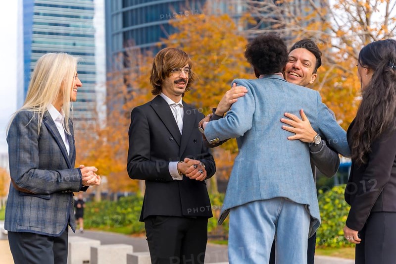Middle-aged multi-ethnic businessmen and businesswomen shaking hands in good working environment