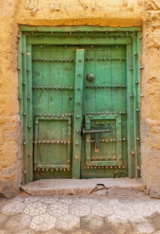 Old green door in the abandoned ghost town of Al Hamra