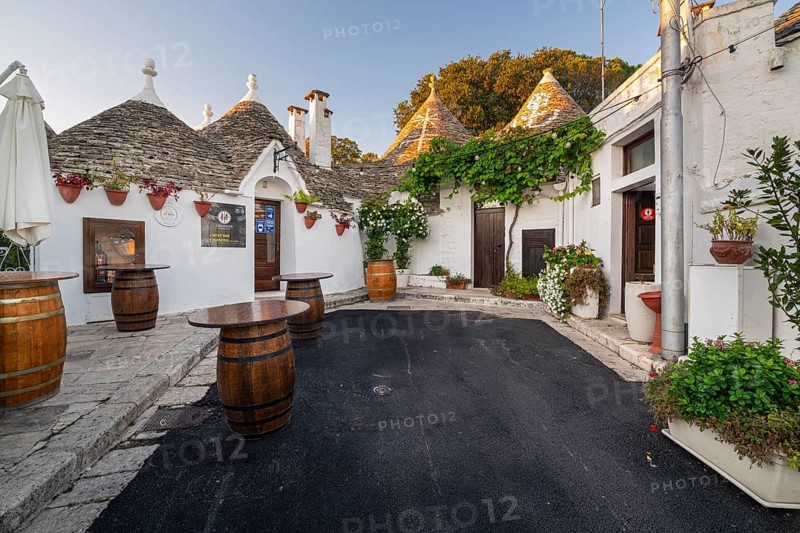 Wine barrels in front of trulli with flowers