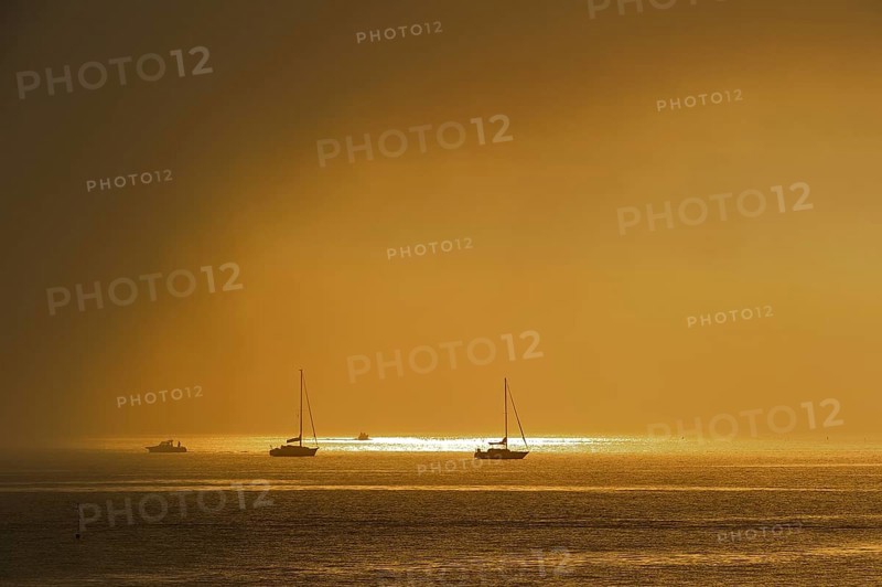 Rain cloud passing over sailing boats at sunset at Saint-Denis-d'Oleron on the island Ile d'Oleron