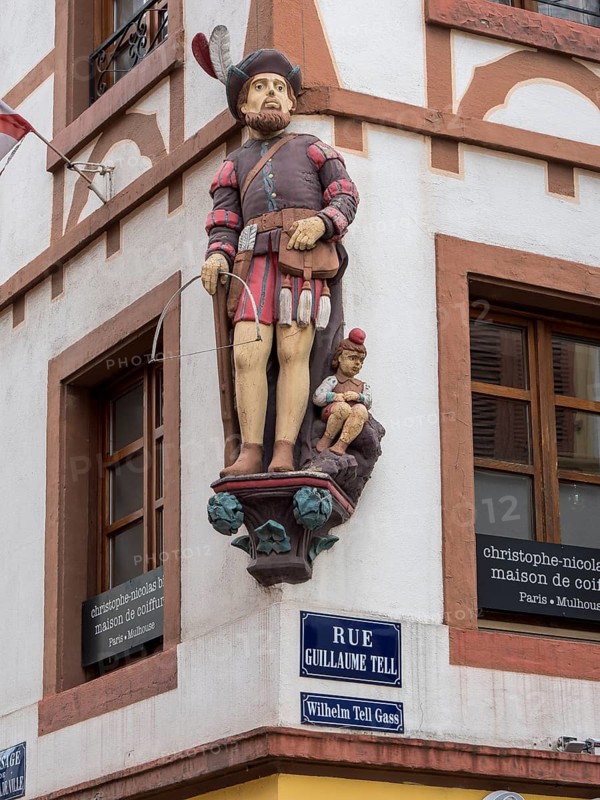 Corner of the half-timbered house with the carved figures of William Tell