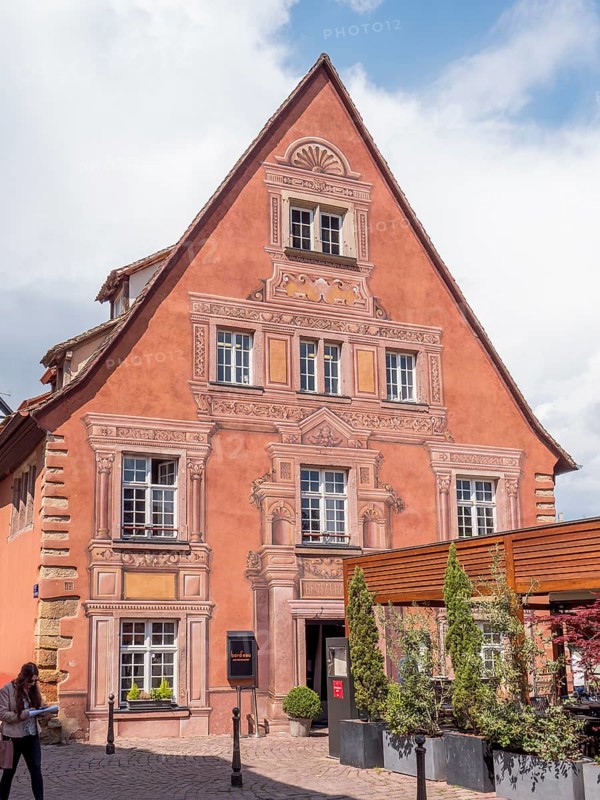 A red building with painted ornaments around the windows and doors in the district of La Petite Venise