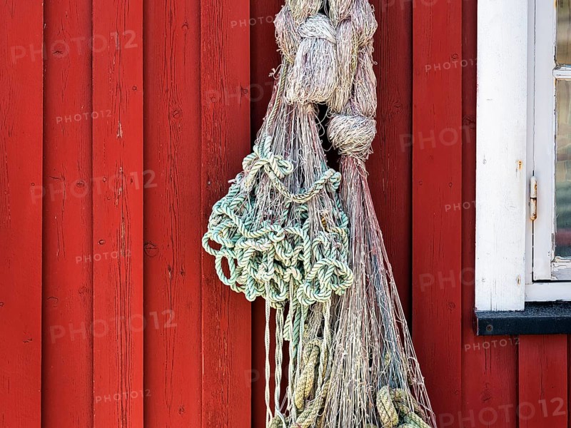 Net hanging from red wooden fishing hut