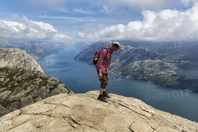 Hiker standing carefully at the rocky outcrop