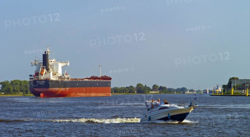 Bulk Carrier YM Endeavour and a pleasure boat on the Weser near Bremen Vegesack