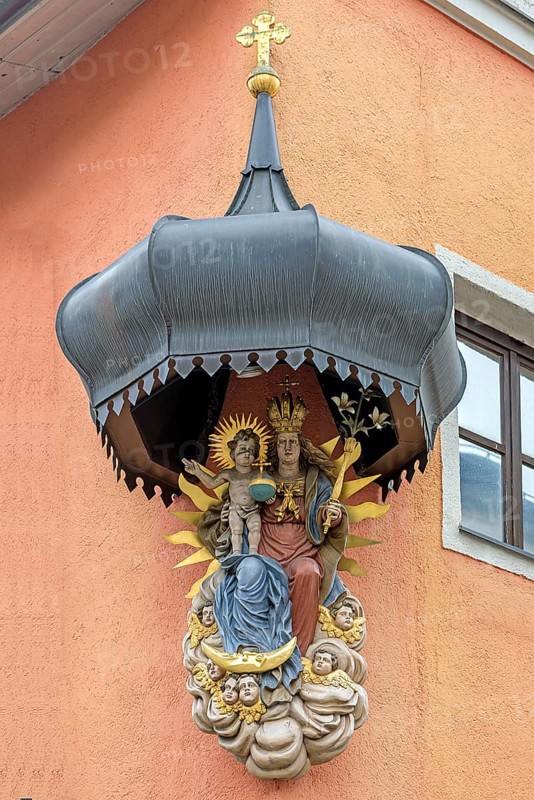 Sacred sculpture of Mary and the Child Jesus under a canopy on a residential house