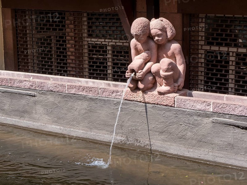 Small statues of a girl and a boy with a jug