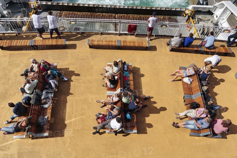 Passengers sitting on benches on deck