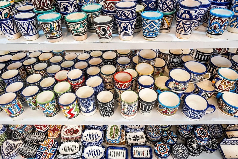 Shelves full of handmade ceramic products in pottery factory in Fez