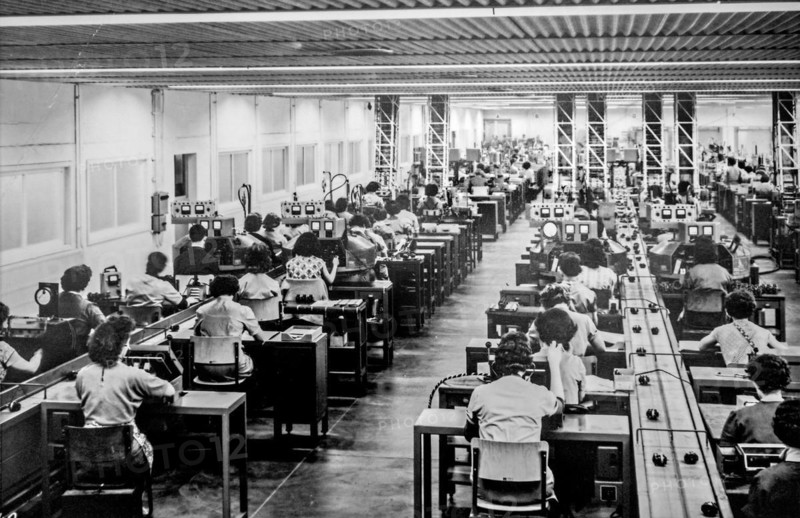 Old black and white archival photograph showing female workers manufacturing small electric motors in factory in the 1950s